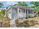 Exterior of home with a inviting front porch, gray siding, and walkway at 1024 Cohassett Ave, Lake Wales, FL 33853