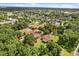 Aerial view highlighting a vast property with mature trees, houses, and a swimming pool at 1055 N Chickasaw Trl, Orlando, FL 32825