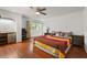 Bright bedroom featuring hardwood floors, ceiling fan and a large bed at 1055 N Chickasaw Trl, Orlando, FL 32825