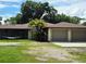 Close up of a charming single-story home with a two-car garage and inviting curb appeal with a well-manicured lawn at 1055 N Chickasaw Trl, Orlando, FL 32825