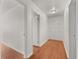 Bright hallway with wood floors and white walls, featuring multiple doorways at 1055 N Chickasaw Trl, Orlando, FL 32825