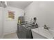 Laundry room with modern washer and dryer, utility sink, and a window at 1055 N Chickasaw Trl, Orlando, FL 32825