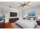 Spacious bedroom with a large flat screen tv, hardwood floors and an area rug at 1055 N Chickasaw Trl, Orlando, FL 32825