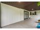 Covered patio featuring white wood paneling, sliding glass door, and a ceiling light at 1055 N Chickasaw Trl, Orlando, FL 32825