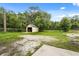Detached storage shed in a spacious, grassy backyard surrounded by mature trees at 1055 N Chickasaw Trl, Orlando, FL 32825