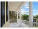 Balcony featuring stately columns, white railing, and neighborhood views beyond mature trees at 1115 Mosaic Dr, Celebration, FL 34747