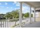 Balcony featuring stately columns, a white railing, and neighborhood views beyond mature trees at 1115 Mosaic Dr, Celebration, FL 34747