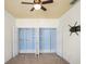 Bedroom features carpet, a ceiling fan, a TV mount and a walk-in closet with custom shelving at 1115 Mosaic Dr, Celebration, FL 34747