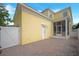 Rear exterior showing a yellow house with screened-in porch and brick paver patio at 1115 Mosaic Dr, Celebration, FL 34747
