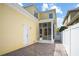 Rear exterior displaying brick patio, screened porch, white fence, and sunny yellow siding at 1115 Mosaic Dr, Celebration, FL 34747