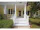 Inviting front porch with classic white pillars and stairs leading to the colorful front door at 1115 Mosaic Dr, Celebration, FL 34747
