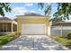 Detached two-car garage with white door, long driveway, and nearby white fence for backyard privacy at 1115 Mosaic Dr, Celebration, FL 34747