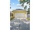 Exterior view of the detached garage with a long driveway and a well-maintained lawn at 1115 Mosaic Dr, Celebration, FL 34747