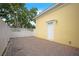 Charming patio with brick pavers, white fence, yellow exterior, and natural light at 1115 Mosaic Dr, Celebration, FL 34747