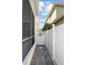 Side yard walkway featuring brick pavers, white fencing, and access gate, connecting outdoor areas at 1115 Mosaic Dr, Celebration, FL 34747
