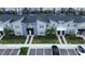 Aerial view of modern townhomes with well maintained landscaping and paved parking spaces for residents and guests at 1160 Kingsbarn St, Davenport, FL 33896