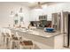 Modern kitchen featuring stainless steel appliances, a large island with seating, and stylish pendant lighting at 1160 Kingsbarn St, Davenport, FL 33896