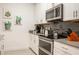 Modern kitchen with stainless steel appliances, white cabinetry, and a gray backsplash at 1160 Kingsbarn St, Davenport, FL 33896