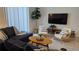 Comfortable living room features a sectional sofa, armchairs, a decorative rug, and a large screen television at 1160 Kingsbarn St, Davenport, FL 33896