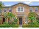 Charming tan two-story home with lush landscaping and a welcoming dark front door at 13758 Daniels Landing Cir, Winter Garden, FL 34787