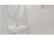 Powder room featuring pedestal sink and oval mirror at 13758 Daniels Landing Cir, Winter Garden, FL 34787