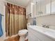 Well-lit bathroom with a tub/shower combo, white cabinets, and wood-look flooring at 143 Piedmont Park Ave, Davenport, FL 33897