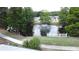 Aerial view of a serene pond with fountain, surrounded by lush landscaping and well-maintained homes at 143 Piedmont Park Ave, Davenport, FL 33897