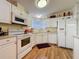 Traditional kitchen with white cabinetry, modern appliances, and wood laminate flooring at 143 Piedmont Park Ave, Davenport, FL 33897