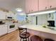 Bright kitchen featuring white cabinets, modern appliances, and a cozy breakfast bar at 143 Piedmont Park Ave, Davenport, FL 33897