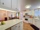 Bright kitchen next to the dining area with white cabinets, and wood laminate flooring at 143 Piedmont Park Ave, Davenport, FL 33897