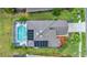 Aerial view of the property showcasing a screened-in pool, lush landscaping, and a well-maintained roof at 1560 The Oaks Blvd, Kissimmee, FL 34746