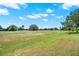 Expansive backyard with a lush green lawn, mature trees, and serene views of the surrounding landscape at 1560 The Oaks Blvd, Kissimmee, FL 34746