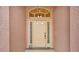 Close up of front door showcasing transom window, sidelights and decorative hardware at 1560 The Oaks Blvd, Kissimmee, FL 34746