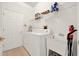 Functional laundry room with a utility sink, shelving, a modern washer and dryer, and ample storage space at 1560 The Oaks Blvd, Kissimmee, FL 34746