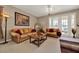 Comfortable living area with neutral carpet, leather couches, and french doors to the exterior at 1560 The Oaks Blvd, Kissimmee, FL 34746