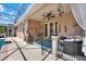Charming covered patio with comfortable seating, decorative accents, and elegant lighting fixtures overlooking the pool at 1560 The Oaks Blvd, Kissimmee, FL 34746