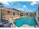 Inviting screened-in pool area with comfortable lounge chairs, elegant statues, and a covered patio area at 1560 The Oaks Blvd, Kissimmee, FL 34746