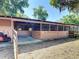 Side view of barn with open stalls and a lawn mower, suggesting a functional space for animals or storage at 1850 Orangewood Ave, St Cloud, FL 34772