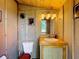 Cozy bathroom featuring rustic wood paneling and a vintage-style sink and toilet at 1850 Orangewood Ave, St Cloud, FL 34772