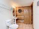 Compact bathroom featuring a pedestal sink, wood paneling, and tile flooring at 1850 Orangewood Ave, St Cloud, FL 34772
