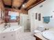 Bright bathroom featuring a shower and soaking tub, neutral tile, and a window at 1850 Orangewood Ave, St Cloud, FL 34772