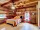 Cozy bedroom featuring wood-paneled walls and ceiling, with a comfortable bed and windows dressed with patterned curtains at 1850 Orangewood Ave, St Cloud, FL 34772