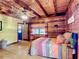 Charming bedroom showcases wood-paneled walls and a vibrant bed, complemented by a view through the window at 1850 Orangewood Ave, St Cloud, FL 34772