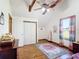 Bright bedroom featuring hardwood floors, vaulted ceiling with exposed beams, and colorful curtains at 1850 Orangewood Ave, St Cloud, FL 34772