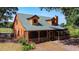 Charming log cabin featuring a metal roof, dormer windows, and a screened-in porch, perfect for relaxing outdoors at 1850 Orangewood Ave, St Cloud, FL 34772