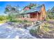 Log cabin with a lush green lawn and a stone-lined garden bed at 1850 Orangewood Ave, St Cloud, FL 34772
