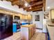 Well-lit kitchen with wood beam ceilings, an island, and blue lower cabinets at 1850 Orangewood Ave, St Cloud, FL 34772