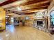 Charming living room featuring a stone fireplace, wood ceiling beams, and hardwood floors, offering a warm and inviting space at 1850 Orangewood Ave, St Cloud, FL 34772