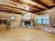 Spacious living room with a stone fireplace, wood-paneled walls, and hardwood floors, creating a rustic and inviting atmosphere at 1850 Orangewood Ave, St Cloud, FL 34772