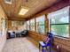 Bright sunroom with wood paneled walls, tile flooring, and multiple windows at 1850 Orangewood Ave, St Cloud, FL 34772